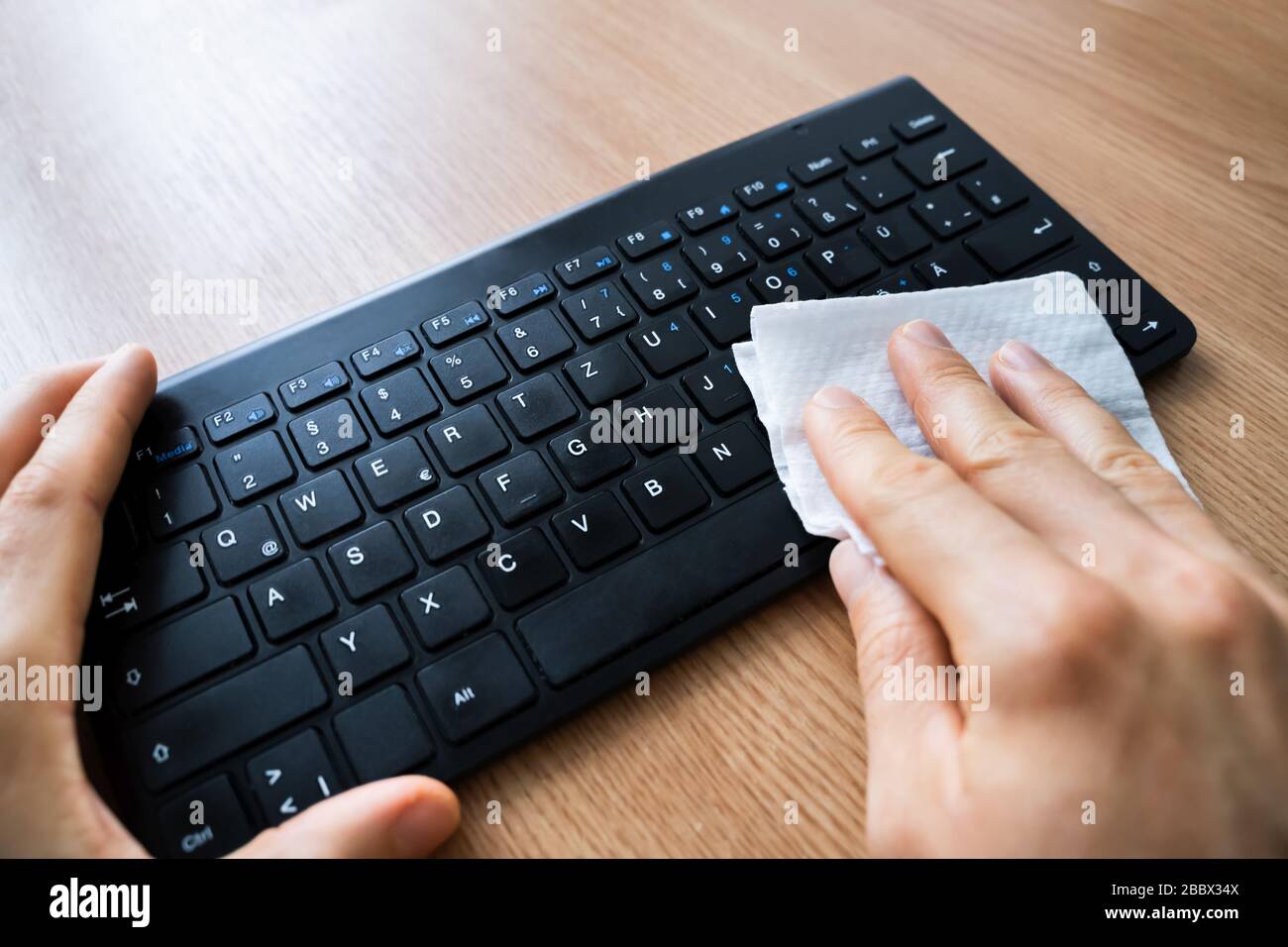 Homme Wiping ordinateur clavier avec aseptisant contre les infections de virus Banque D'Images