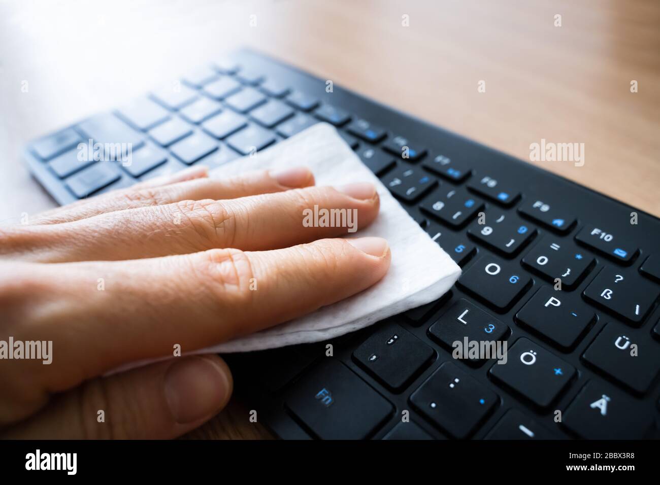 Homme Wiping ordinateur clavier avec aseptisant contre les infections de virus Banque D'Images