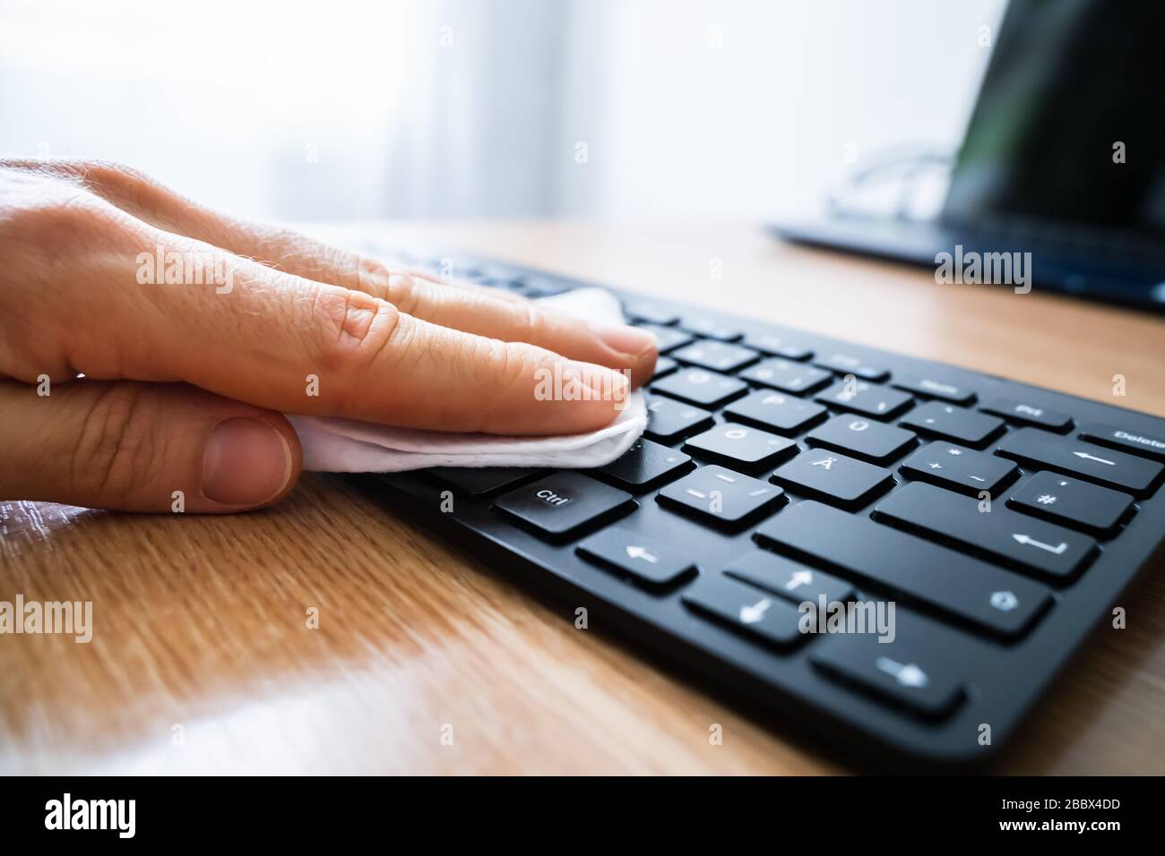 Homme Wiping ordinateur clavier avec aseptisant contre les infections de virus Banque D'Images