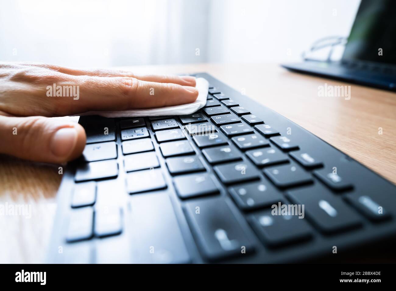 Homme Wiping ordinateur clavier avec aseptisant contre les infections de virus Banque D'Images