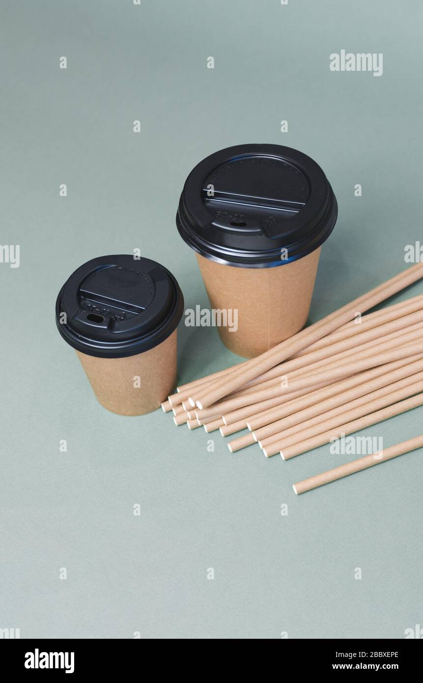 Tasses à café artisanales avec paille de papier sur fond gris. Design écologique. Zéro déchet, articles sans plastique Banque D'Images