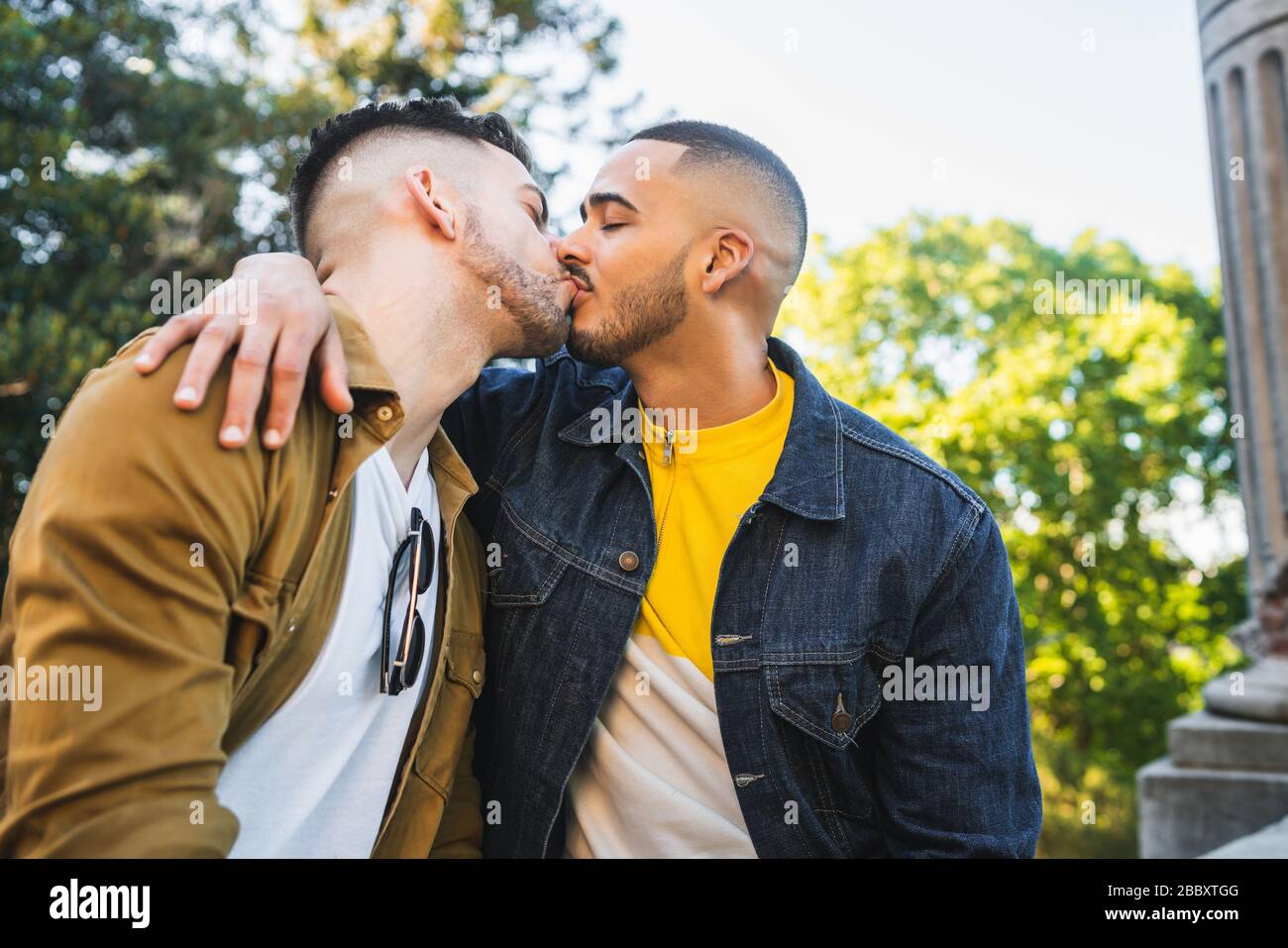 Portrait de heureux couple gay passer du temps ensemble et baiser au parc. LGBT et concept d'amour. Banque D'Images