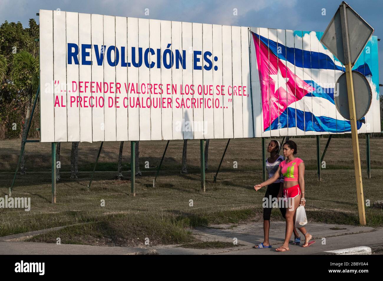 Waliking femme par affiche de propagande sur l'avenue de l'aéroport de la Havane Banque D'Images