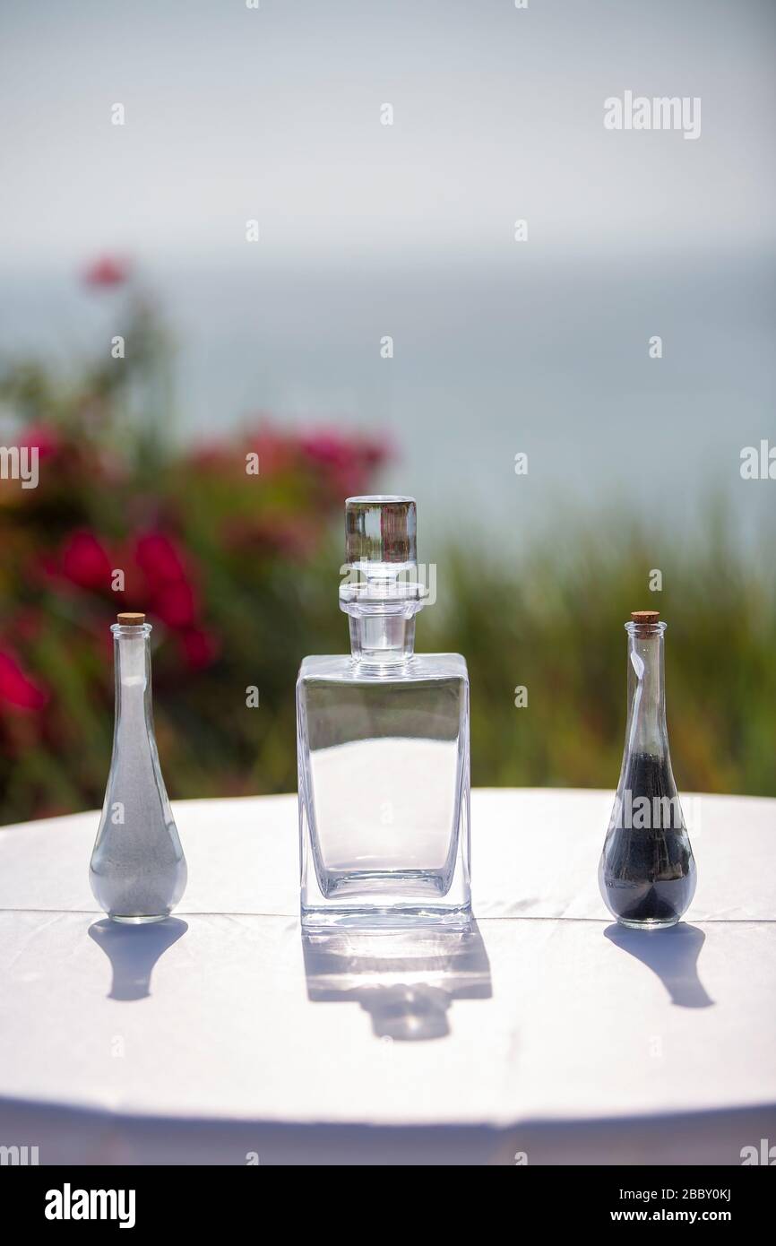 Videz le décanteur de cristal au milieu d'une table avec deux shakers au sel et au poivre sur la nappe de lin blanc Banque D'Images