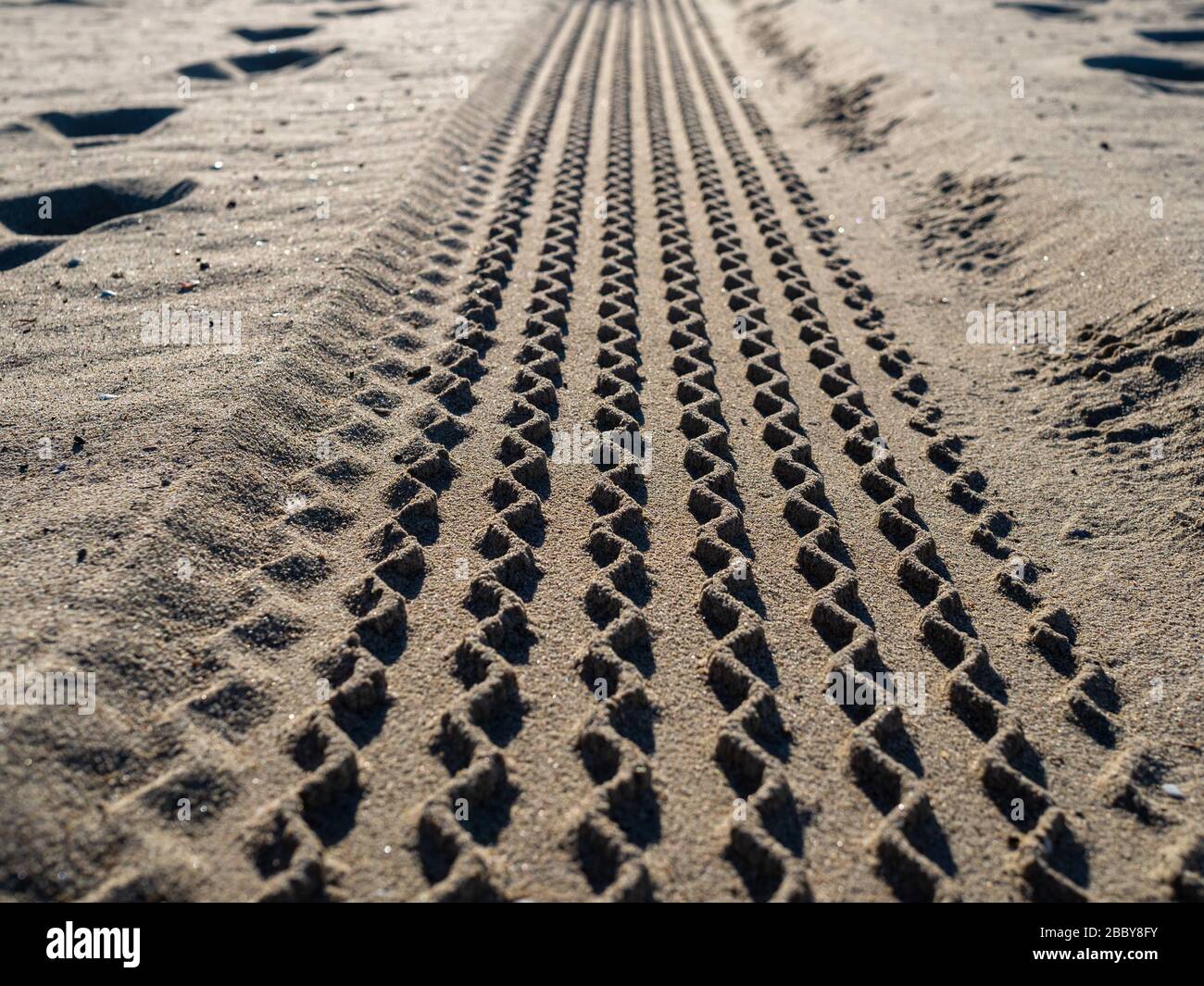 Vue rapprochée des marques de pneus sur le sable de plage Banque D'Images