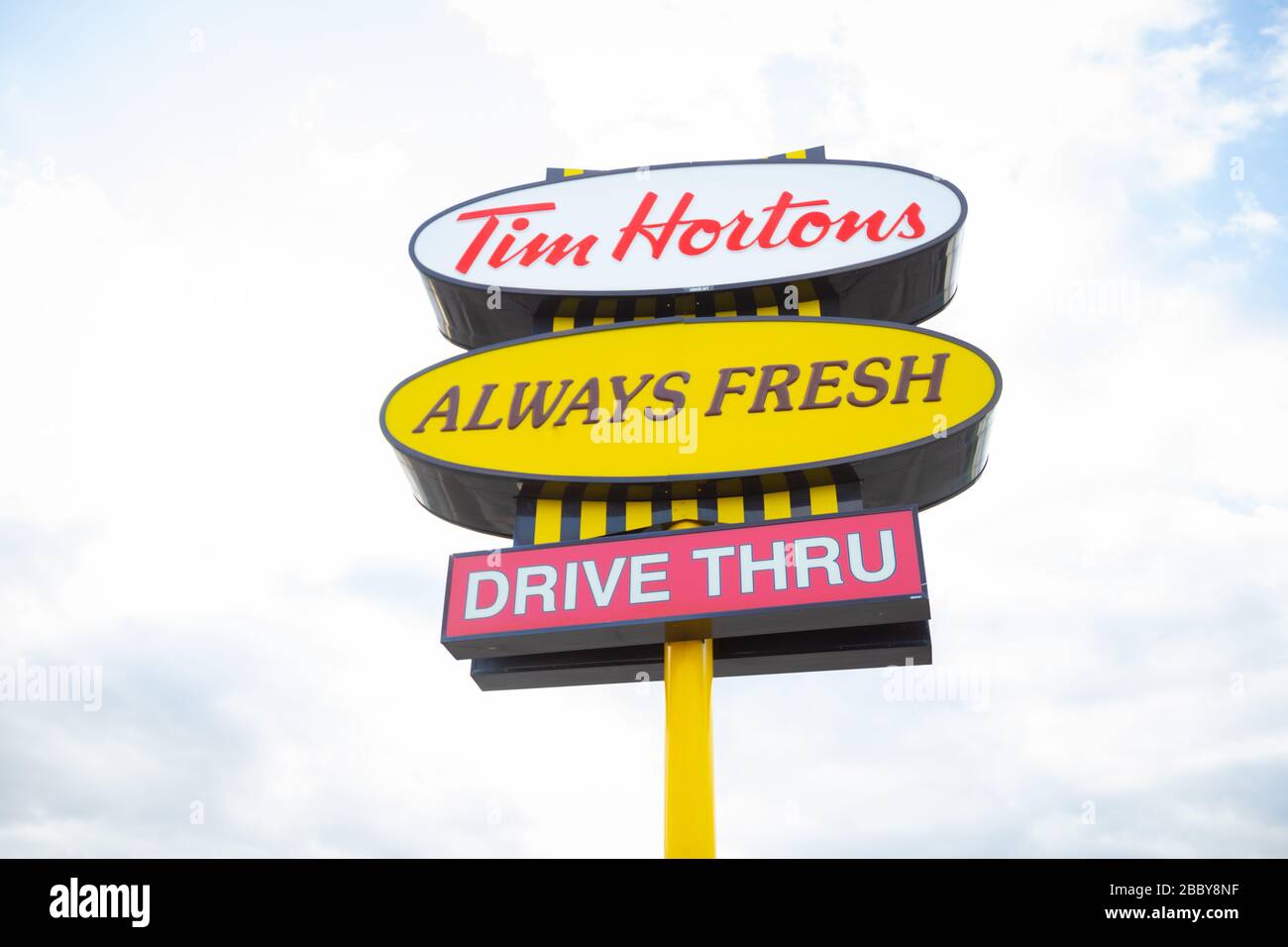Affiche montrant le logo et le texte du restaurant Tim Hortons fast food sur fond de ciel Banque D'Images