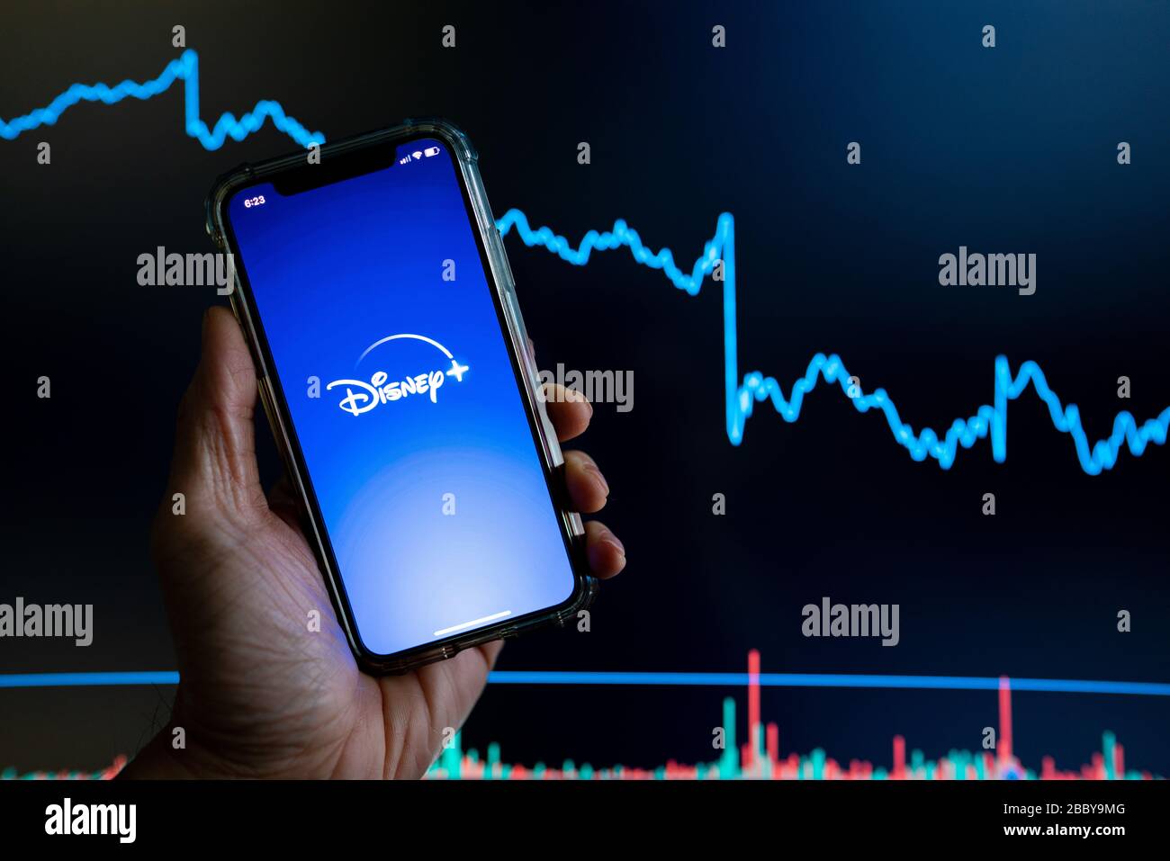 L'application Disney plus s'est tenue contre un tableau de négociation des actions sombres qui a baissé en valeur Banque D'Images