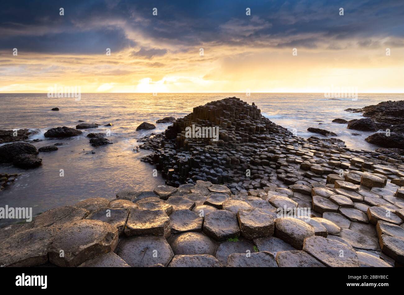 Un coucher de soleil épique sur la chaussée des Géants avec ses colonnes de basalte emblématiques. Comté d'Antrim, région d'Ulster, Irlande du Nord, Royaume-Uni. Banque D'Images