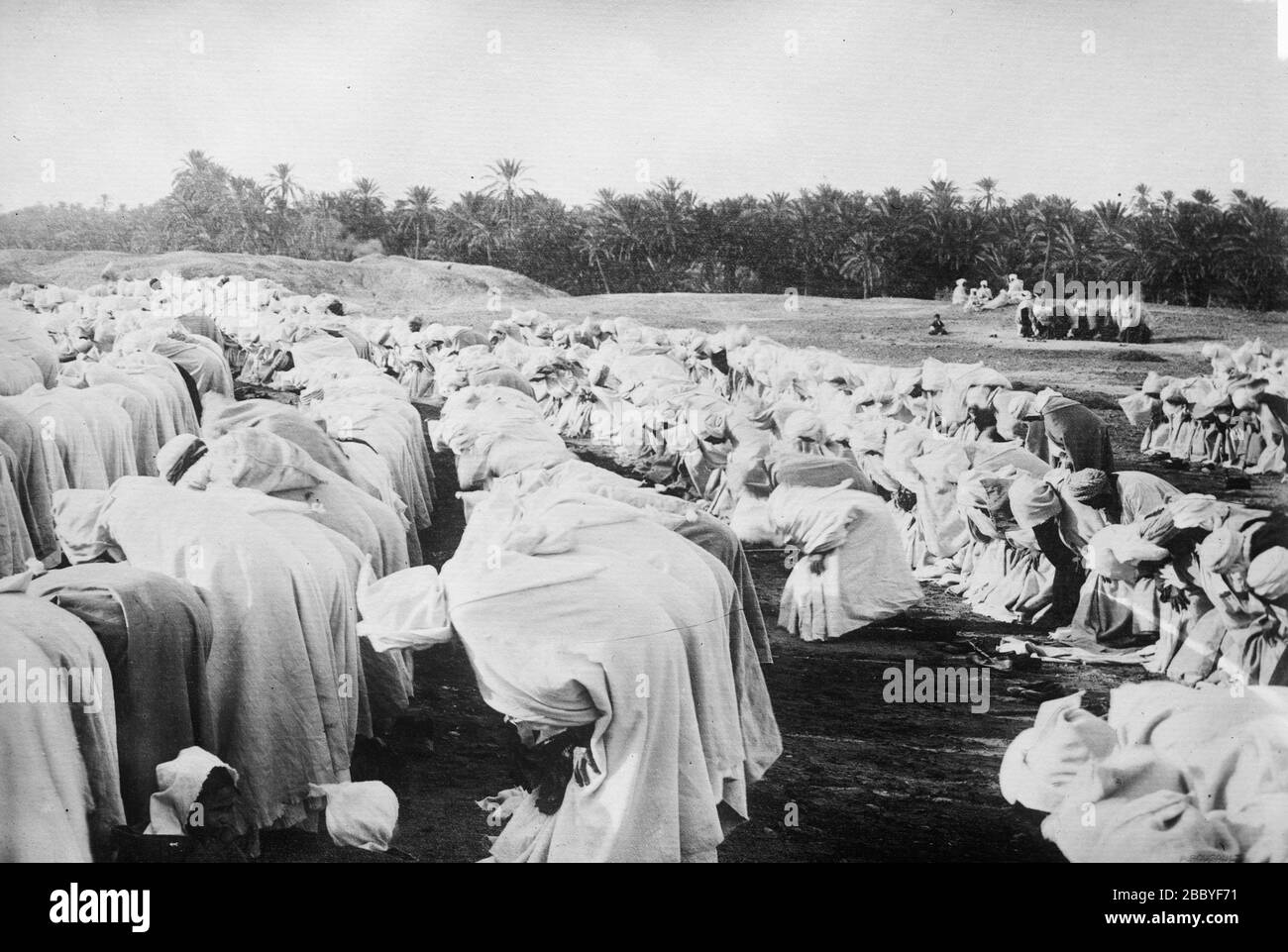 Des hommes arabes priant dans le désert CA. 1910-1915 Banque D'Images