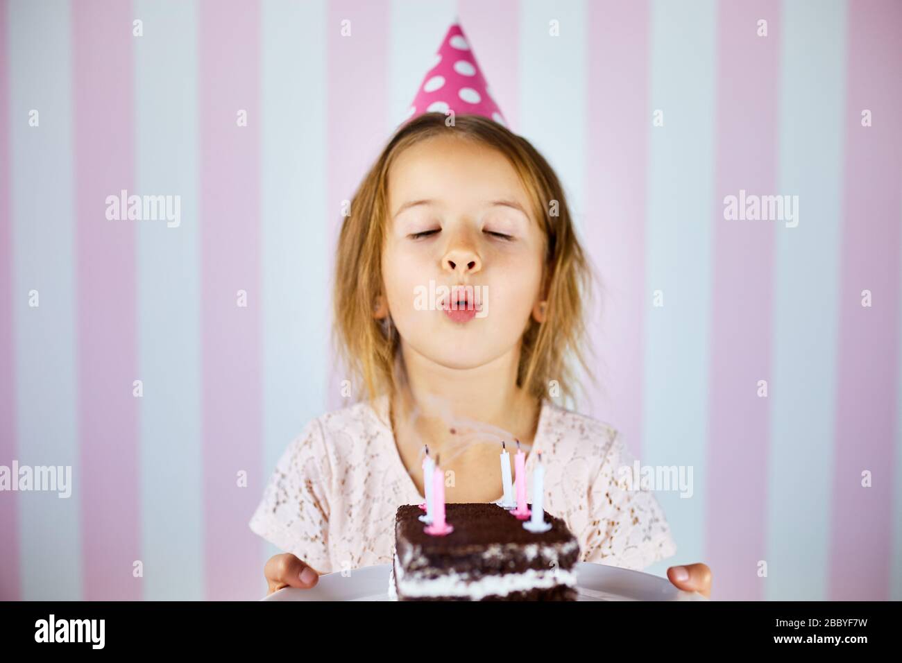 Petite Fille Dans Une Casquette Rose Soufflant Des Bougies Sur Un Gateau De Chocolat D Anniversaire Sur Sa Fete D Anniversaire A La Maison Portrait Anniversaire Enfant Photo Stock Alamy