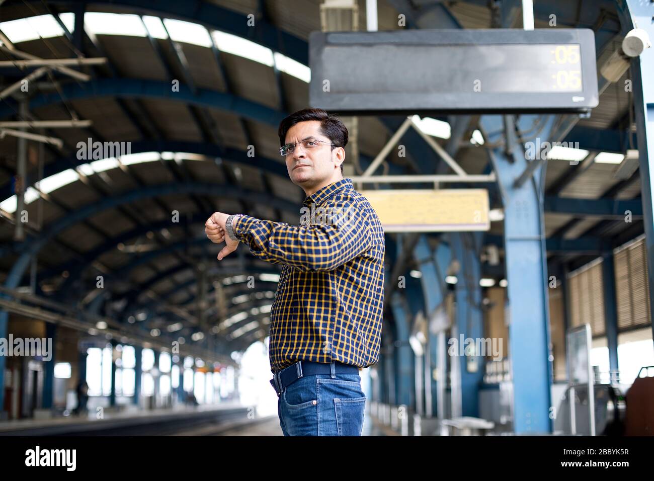 Homme en train de vérifier l'heure en attendant à la station de métro Banque D'Images