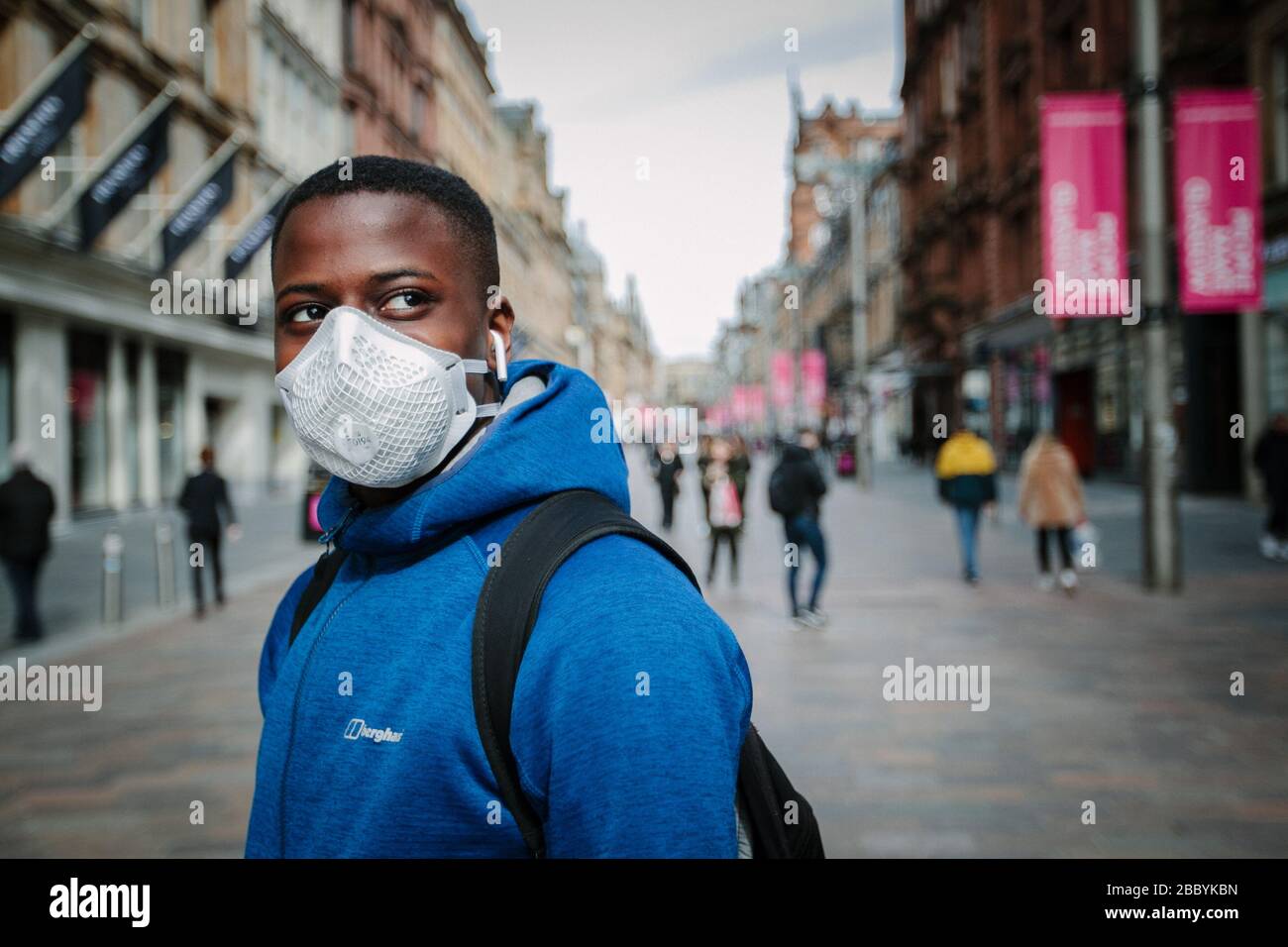 Homme portant un masque lors de la pandémie du virus Corona, dans le centre-ville de Glasgow, au Royaume-Uni. Banque D'Images