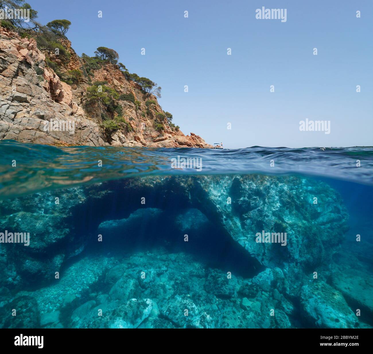 Côte rocheuse et grande roche avec un trou sous l'eau, vue partagée sur et sous l'eau, mer méditerranéenne, Espagne, Costa Brava, Catalogne Banque D'Images