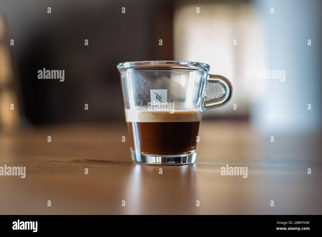 Verre de café transparent par Nespresso sur une table avec fond flou Banque D'Images