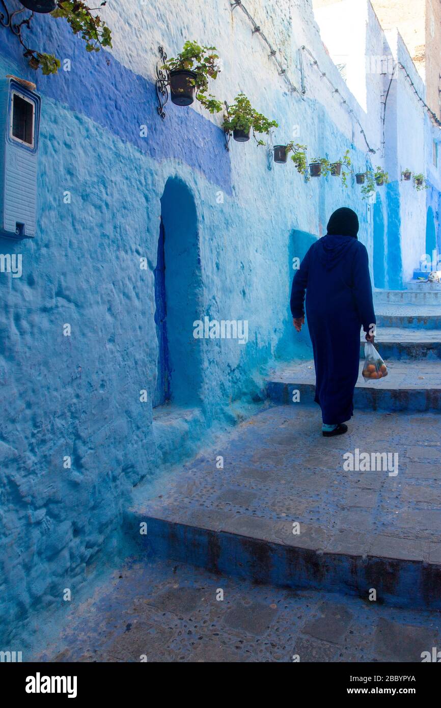 Chefchaouen, Maroc : femme voilée marchant dans la Médina Banque D'Images