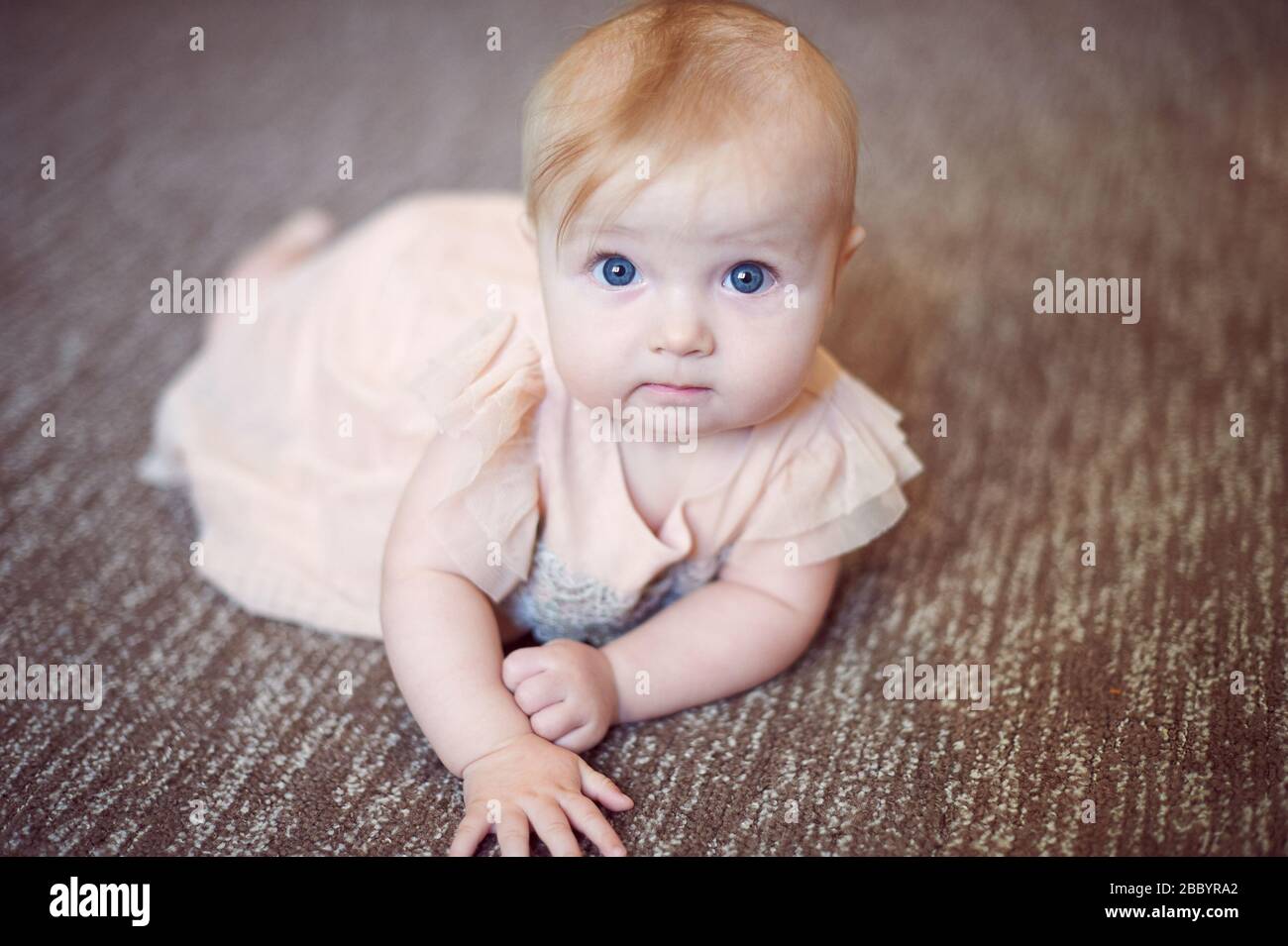 Portrait d'un bébé doux portant une robe rose en studio Banque D'Images