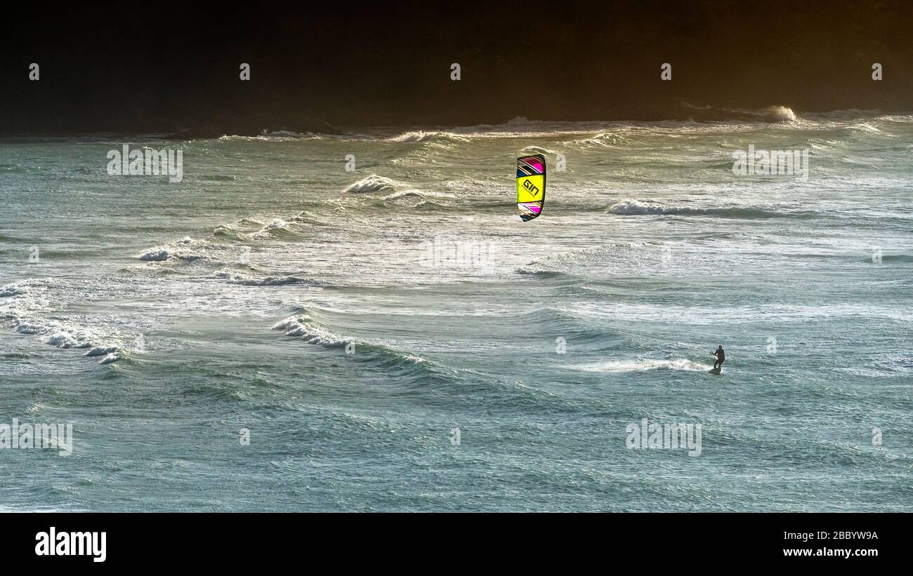 Une image panoramique d'un bateau à kite solitaire qui écume à vitesse sur la mer à Crantock, à Newquay, en Cornouailles. Banque D'Images