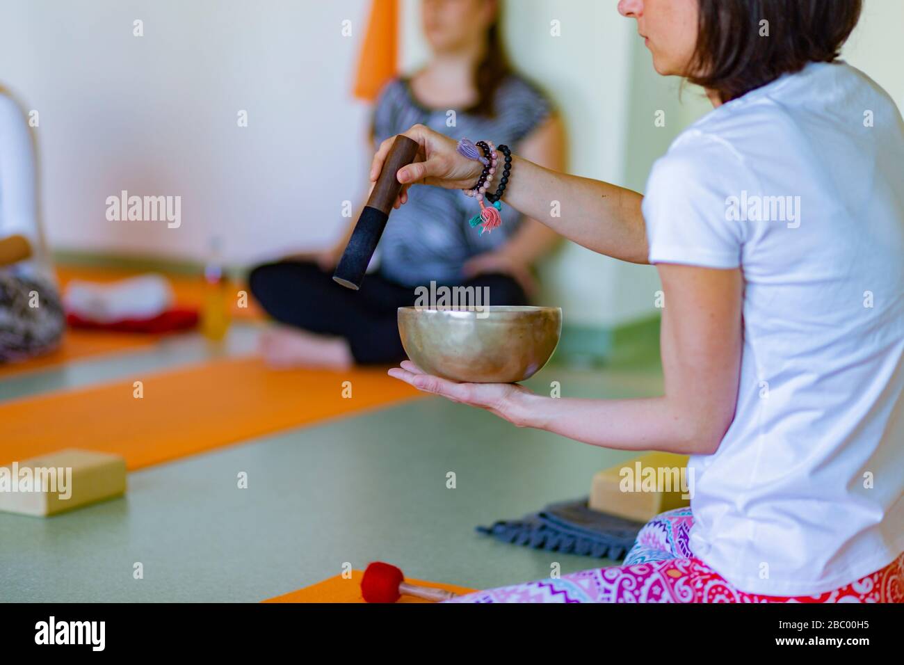 Relaxation du bol de chant dans un cours de yoga Banque D'Images