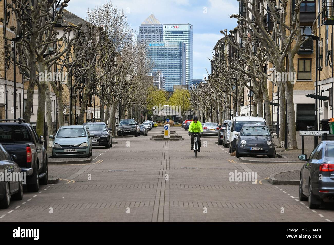 Un cycliste se déplace dans des rues vides en vue de Canary Wharf, dans l'est de Londres, tandis que le Royaume-Uni continue de se verrouiller pour aider à freiner la propagation du coronavirus. Banque D'Images