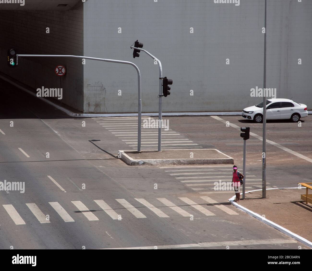 Une vue large en tant que piéton isolé attend de traverser la rue à Brésilia, capitale du Brésil. Banque D'Images