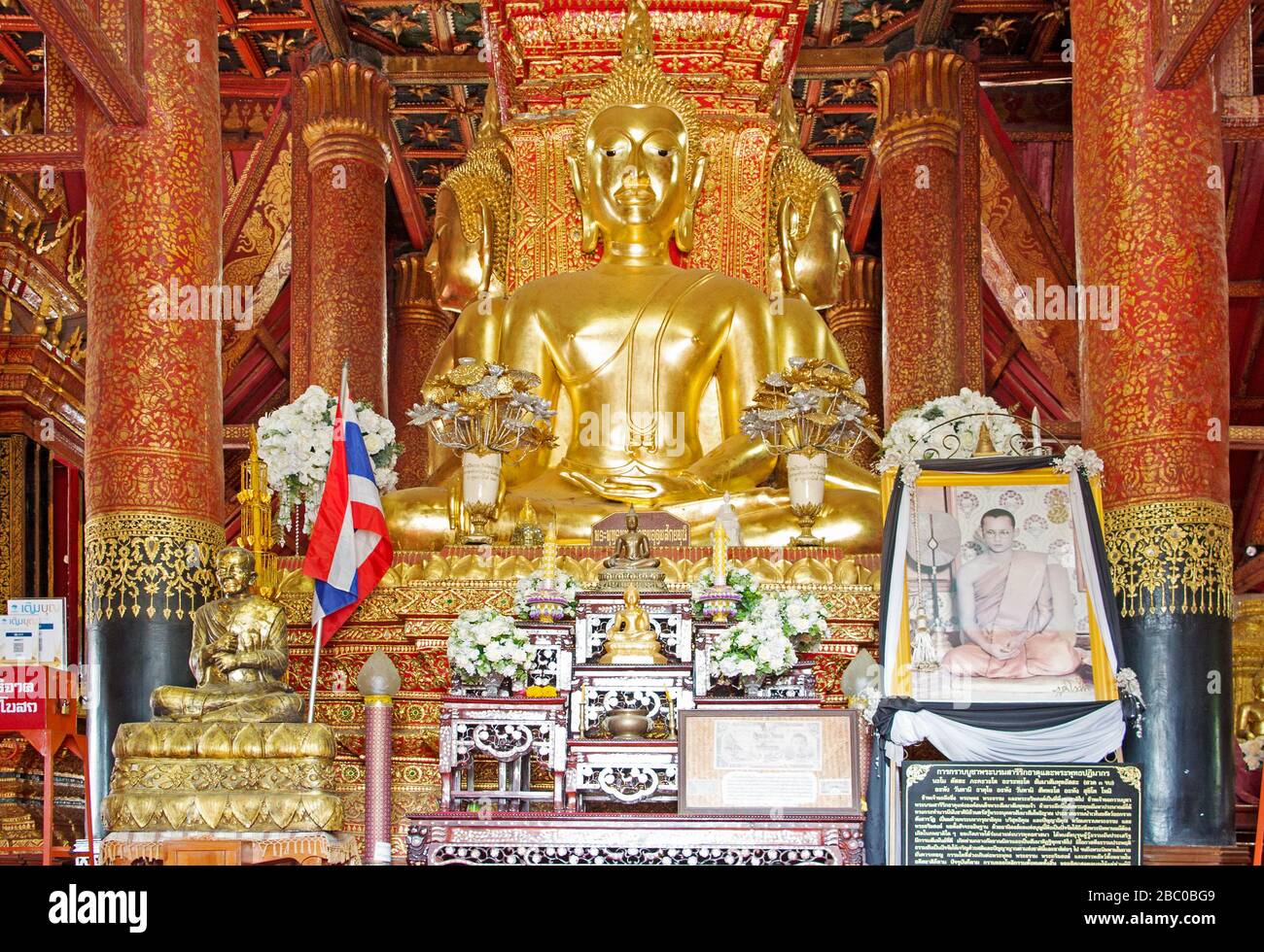 Bouddha assis domine l'espace central du temple en position terre-touchante entouré de quatre énormes piliers en teck. Banque D'Images