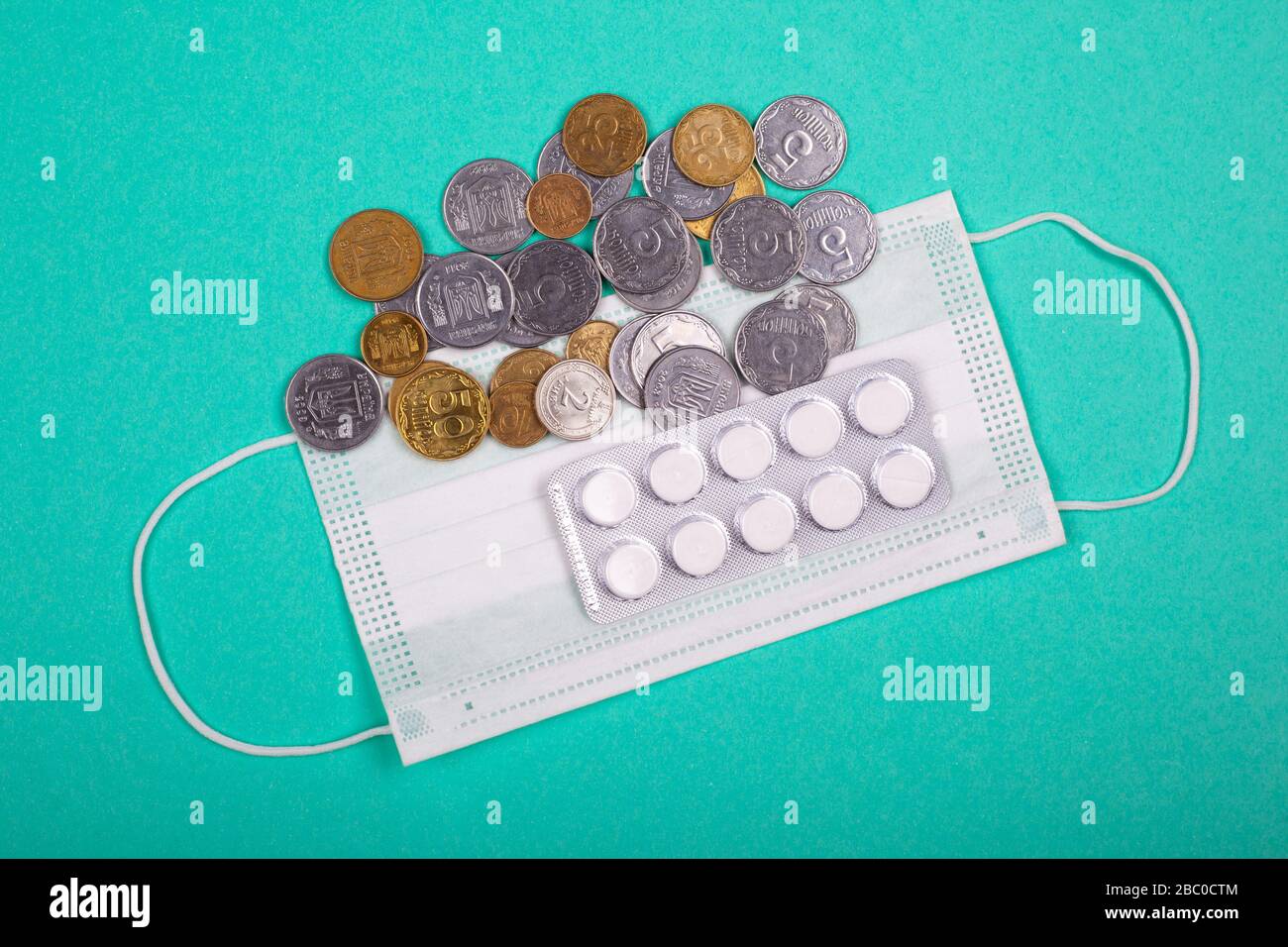 hausse des prix des masques médicaux, du masque protecteur et d’une poignée de pièces sur fond bleu hausse des prix de la médecine due à la pandémie de coronaviru Banque D'Images