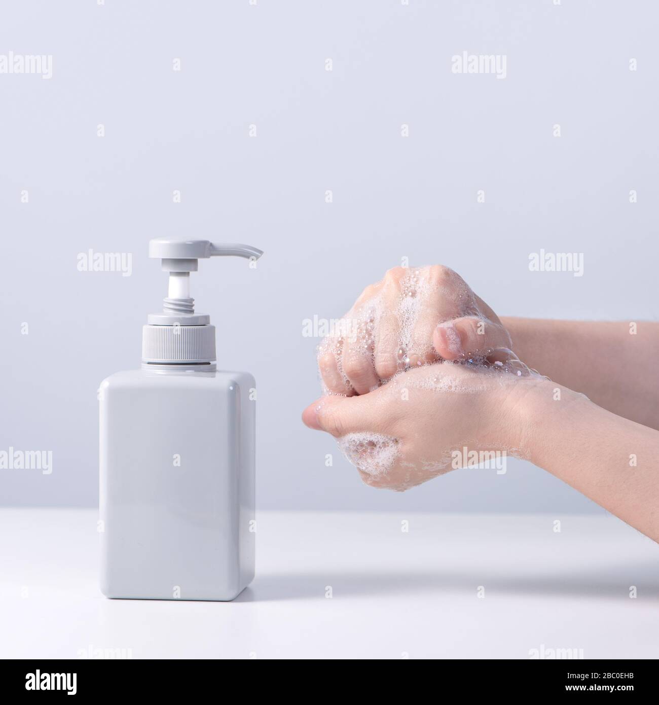 Main de lavage. Jeune femme asiatique utilisant du savon liquide pour se  laver les mains, concept d'hygiène pour arrêter la propagation du  coronavirus isolé sur fond blanc gris, c Photo Stock -