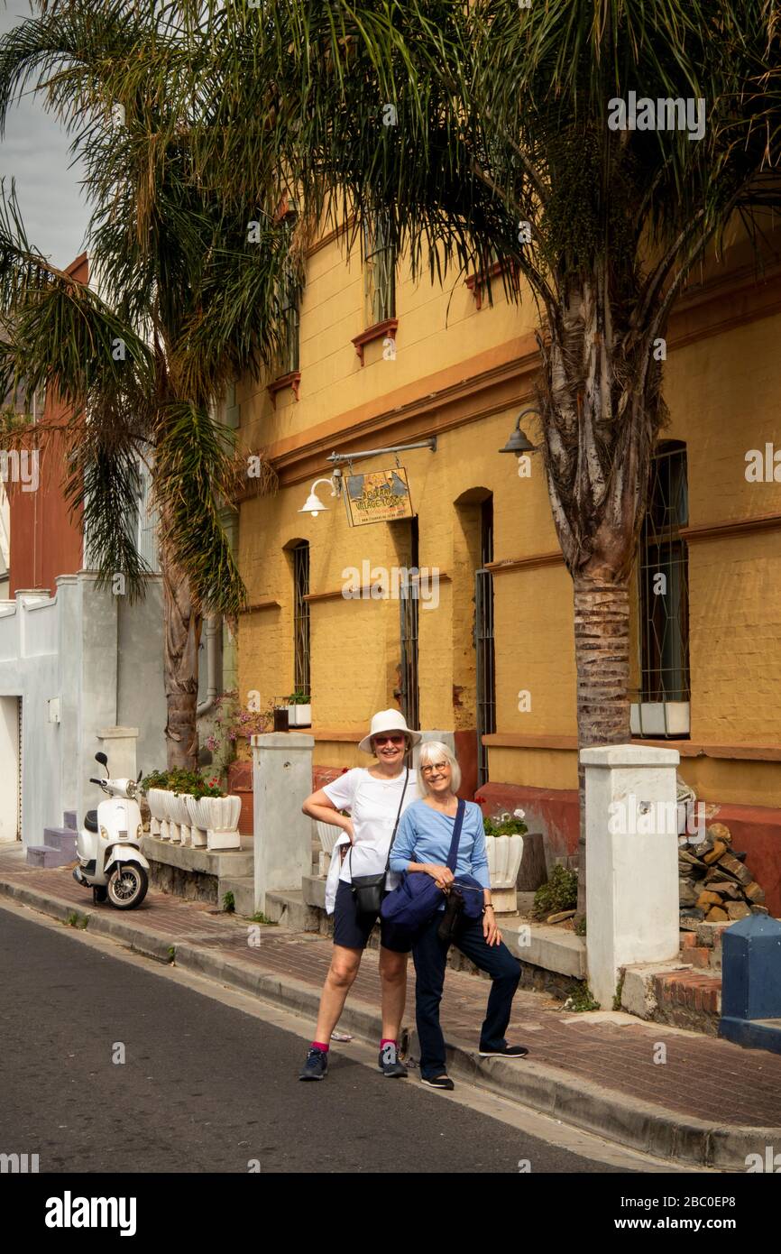 Afrique du Sud, le Cap, Schotsche Knoof, Bo Kaap, Chiappini St, deux touristes féminins en dehors du Bo Kaap Village Lodge Banque D'Images