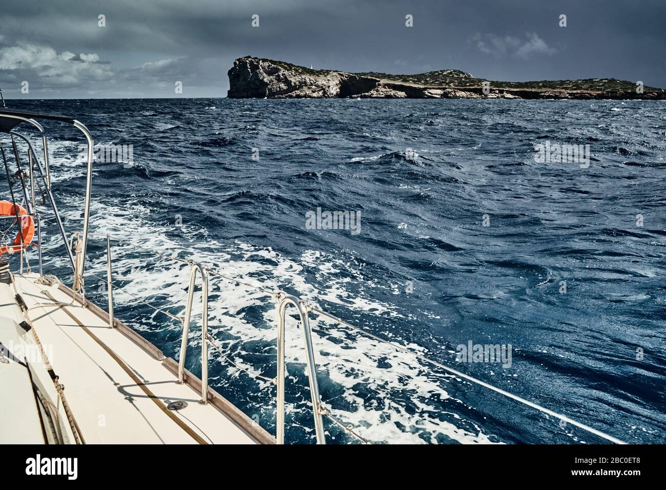 Vue sur la mer et les montagnes depuis le voilier, bord d'une planche de bateau, élingues et cordes, éclaboussures sous le bateau, temps ensoleillé Banque D'Images