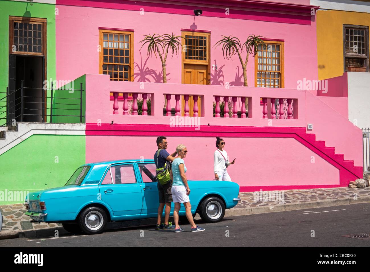 Afrique du Sud, le Cap, Schotsche Knoof, Bo Kaap, Wale St, les touristes sur le Mark2 peint en bleu Ford Cortina stationné à l'extérieur colorentièrement peint restauré ho Banque D'Images