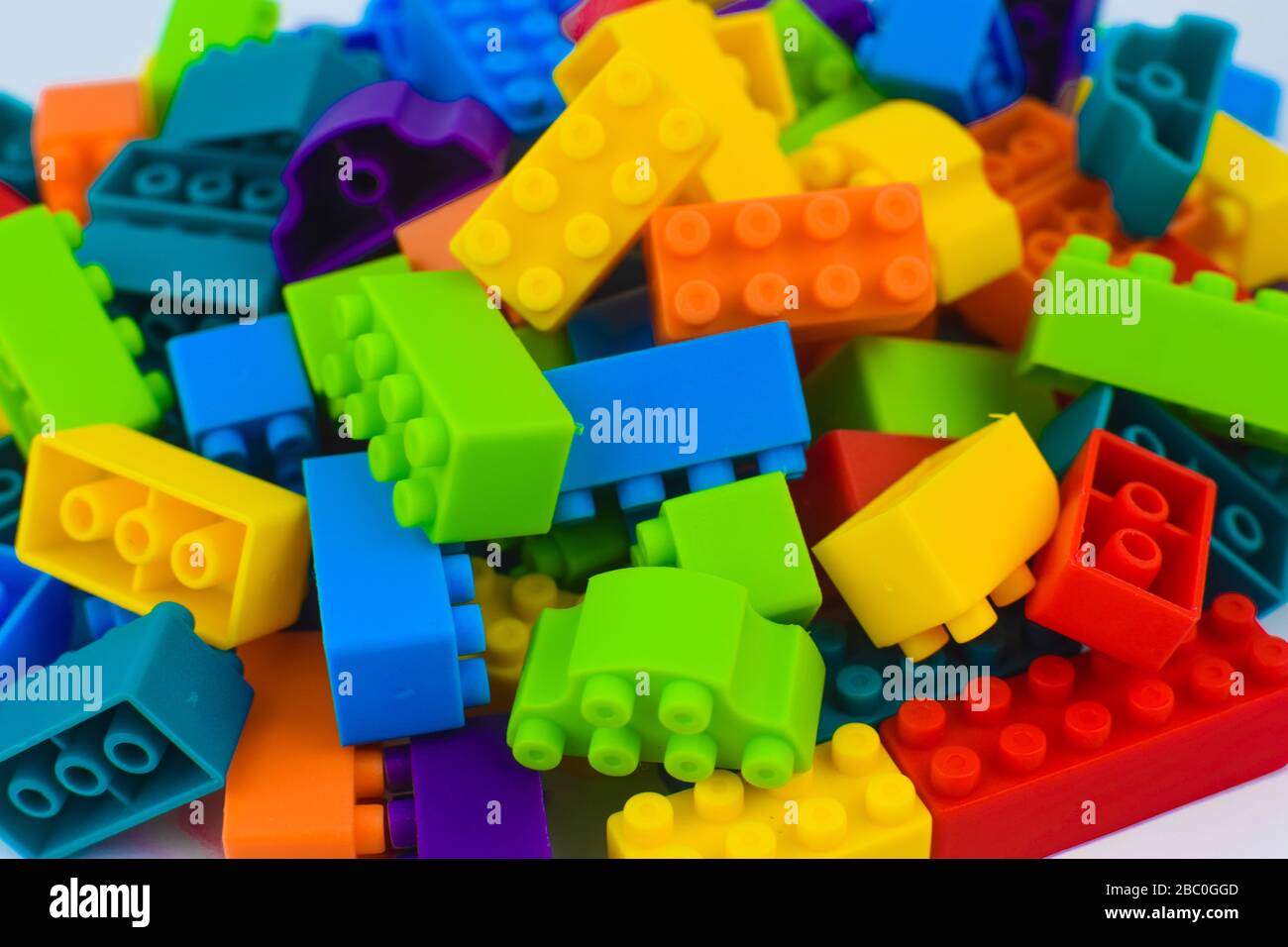 Beaucoup de blocs de construction de couleurs différents réunis avant un arrière-plan blanc isolé Banque D'Images