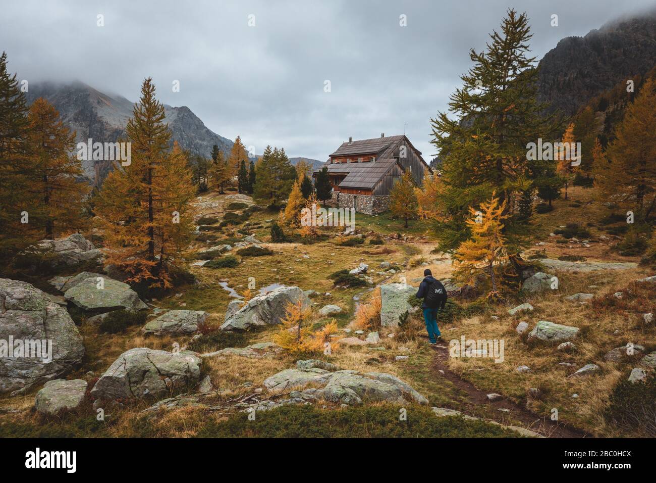 LE RANDONNEUR S'APPROCHANT DU REFUGE DE LA COUGOURDE, COULEURS D'AUTOMNE, PARC NATIONAL DU MERCANTOUR, SAINT-MARTIN-VESUBIE, PROVENCE-ALPES-CÔTE-D'AZUR, (06) ALPES-MARITIMES, FRANCE Banque D'Images
