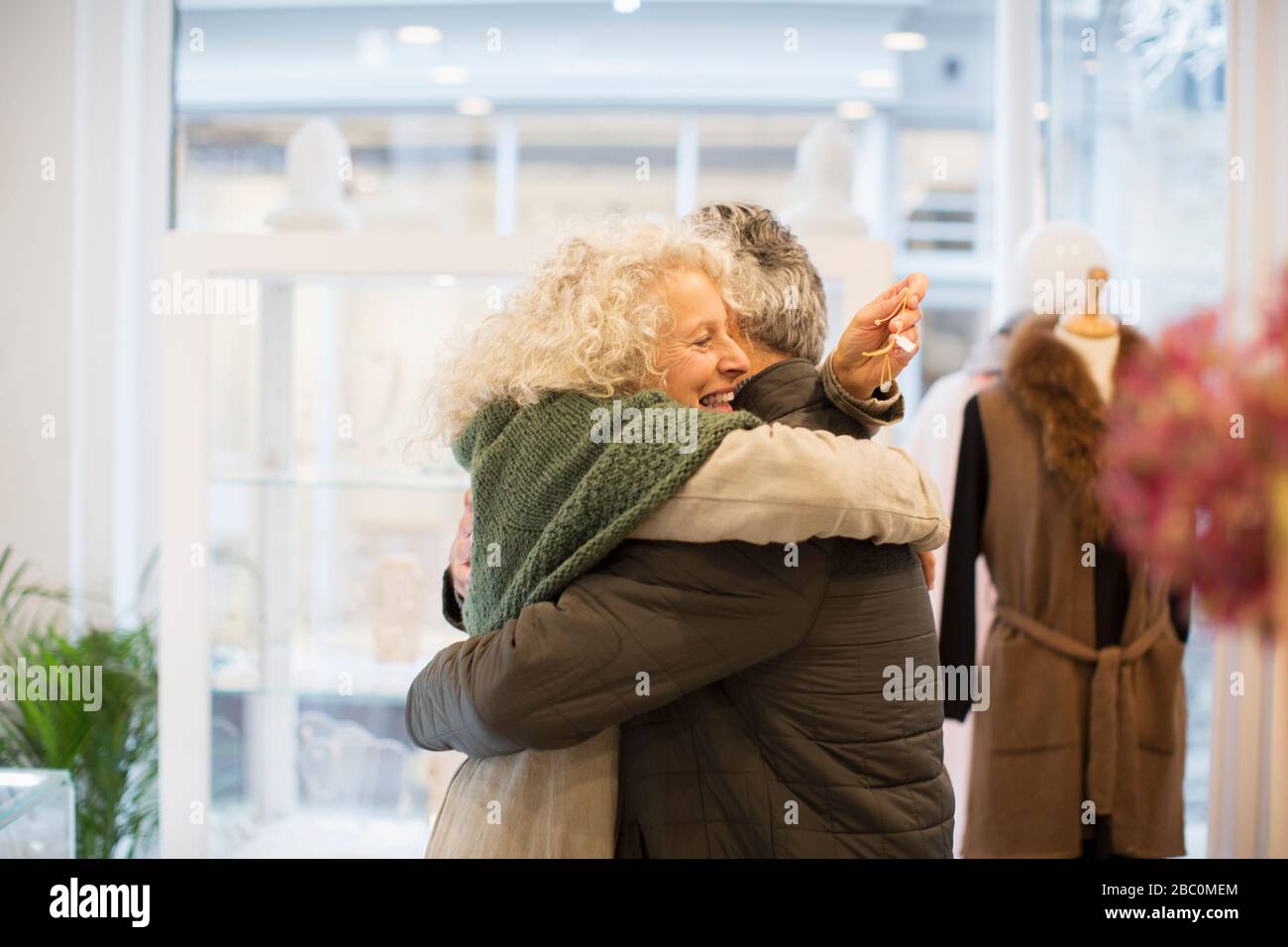 Heureuse femme senior embrassant mari dans la bijouterie Banque D'Images