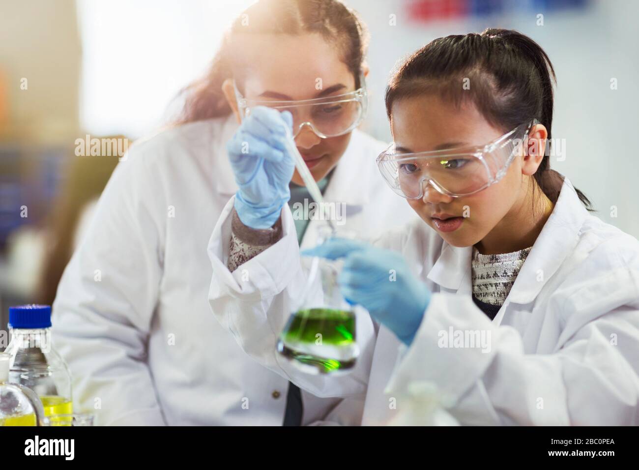 Des filles qui mènent des expériences de chimie en laboratoire de classe Banque D'Images