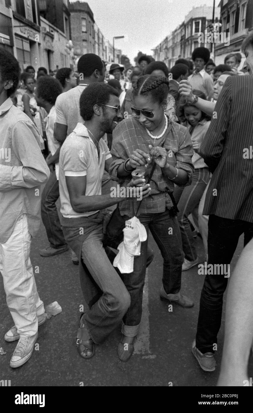 Notting Hill Carnival groupe de couple noir célébrant la fête, ayant amusant dansant la danse Bump dans la nuit. 1980 ROYAUME-UNI HOMER SYKES Banque D'Images