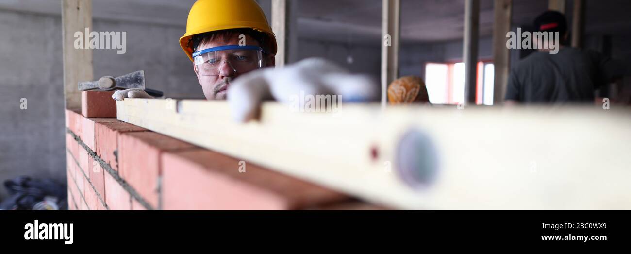 Le casque de type construction mesure le travail de brickwork de niveau Banque D'Images