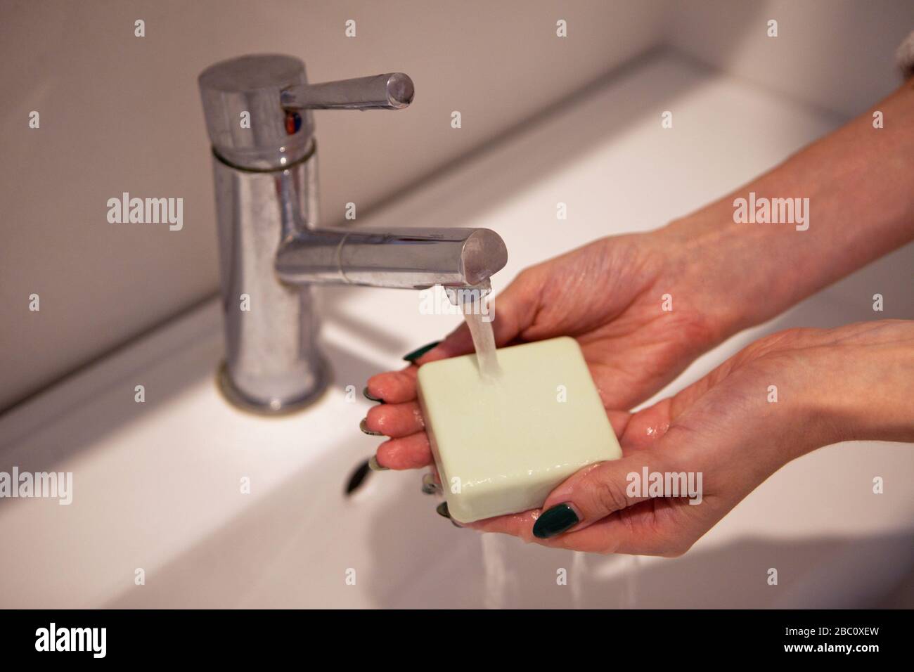 laver les mains avec du savon dans la salle de bain. Laver les mains avec du savon sous la grue avec de l'eau Banque D'Images