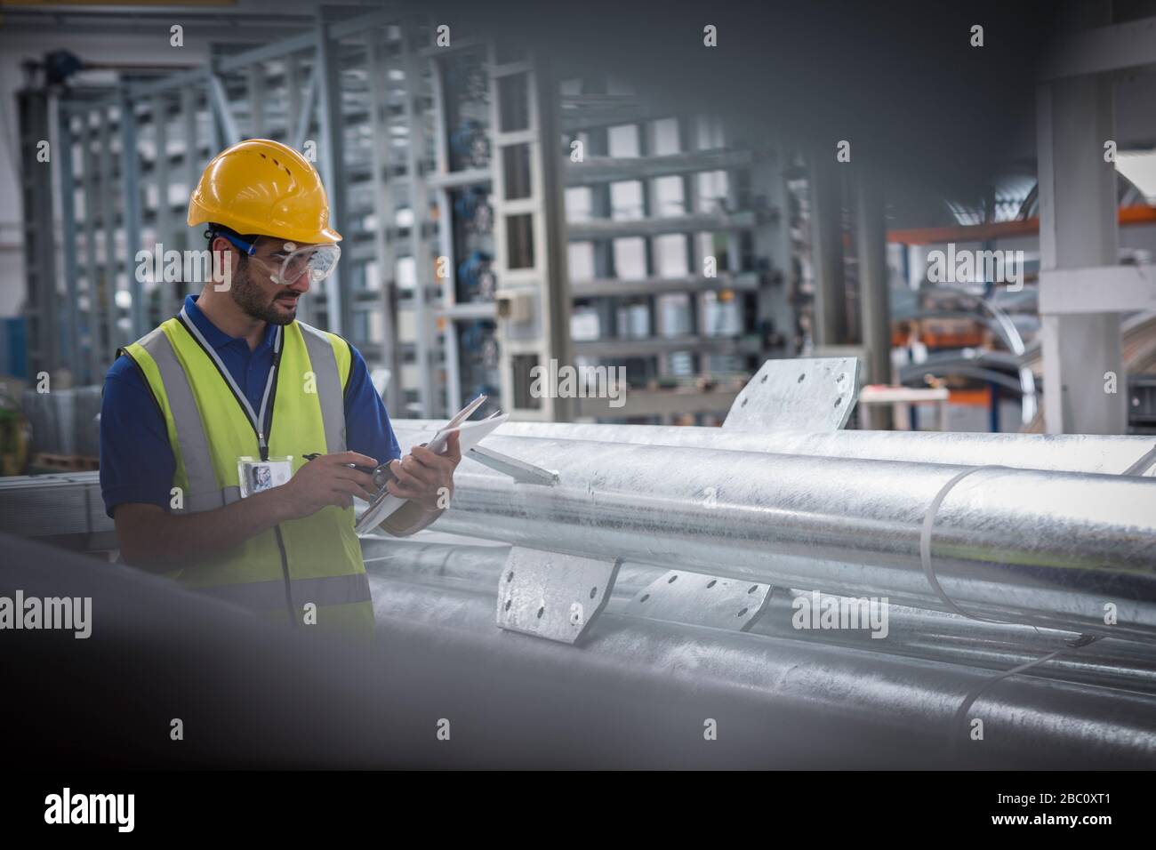 Travailleur masculin utilisant une tablette numérique dans une usine d'acier Banque D'Images