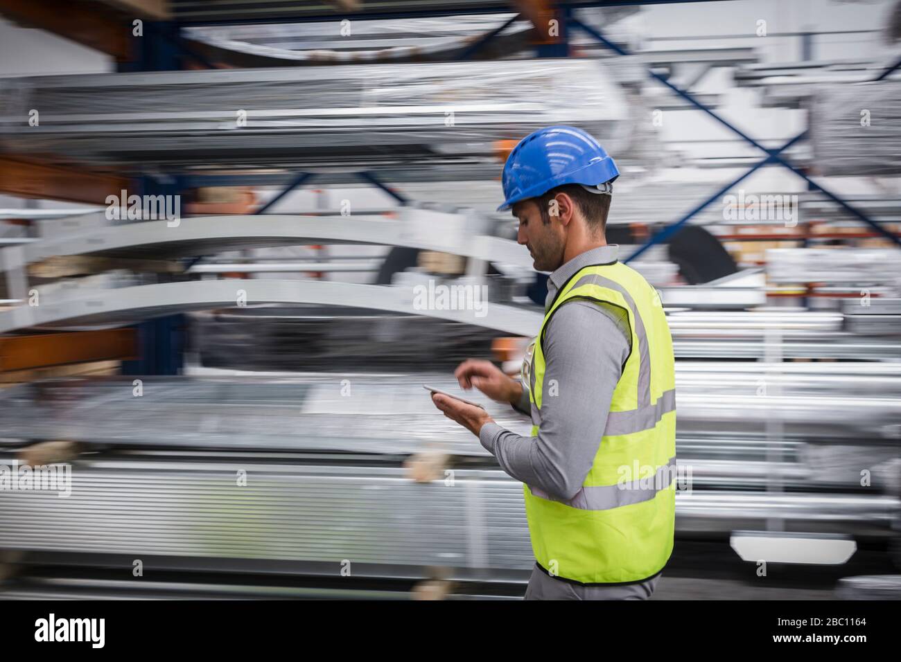 Travailleur masculin utilisant une tablette numérique dans une usine d'acier Banque D'Images