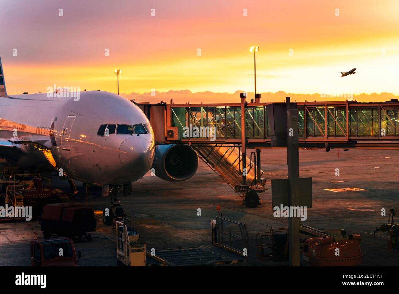 Avion en train de descendre au ciel et un avion prêt à monter à bord, aéroport au lever du soleil à Barcelone, Espagne Banque D'Images