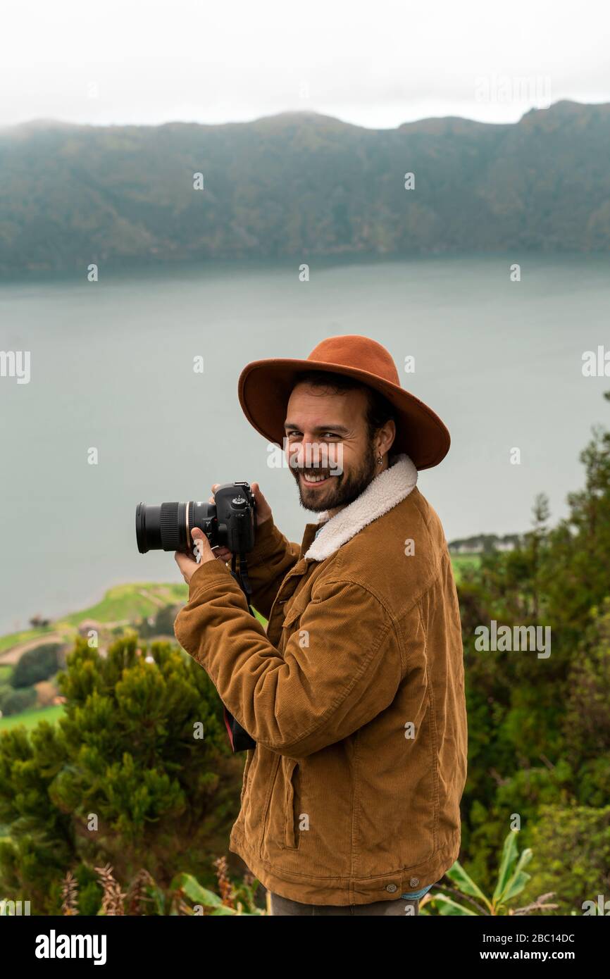 Portrait d'un homme souriant avec appareil photo debout sur un lac, île de Sao Miguel, Açores, Portugal Banque D'Images