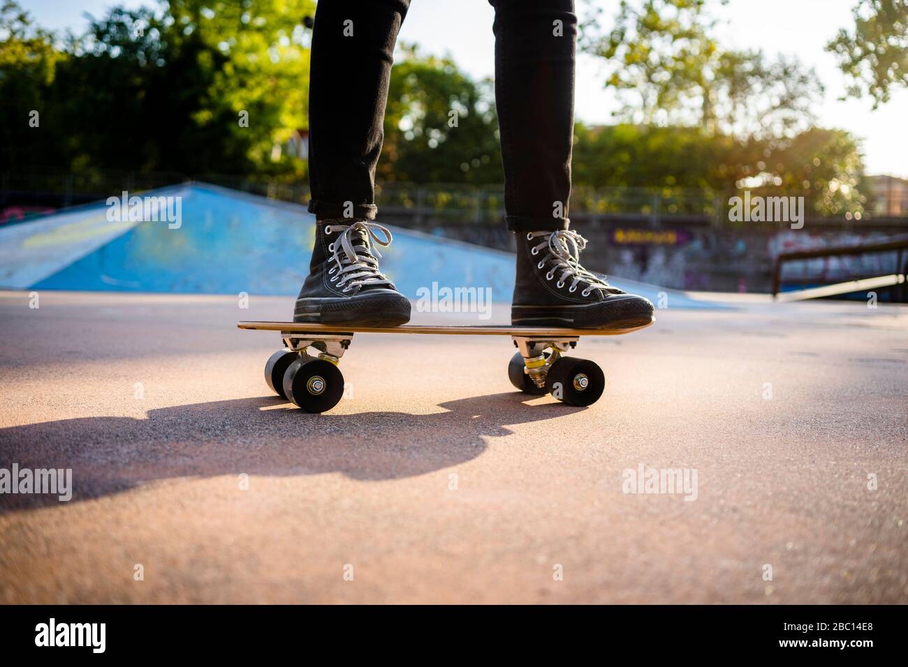 Jeune femme debout sur le skateboard Banque D'Images