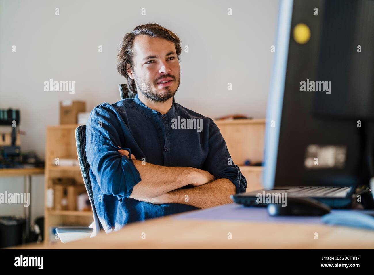 Portrait d'un homme d'affaires assis au bureau dans un bureau en bois à aire ouverte Banque D'Images