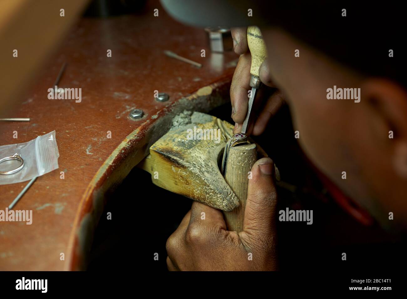 Homme répare une bague avec un diamant manquant Banque D'Images
