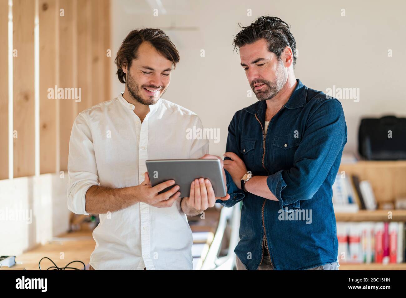 Deux hommes d'affaires avec tablette en bois à plan ouvert bureau Banque D'Images