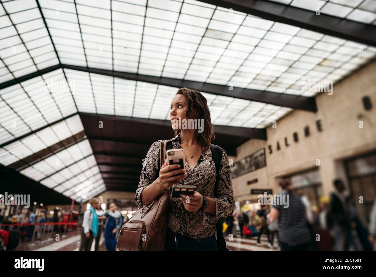 Jeune femme avec téléphone portable dans un bâtiment de la ville Banque D'Images