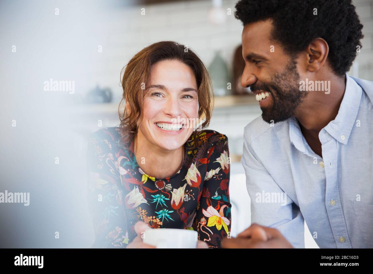 Portrait souriant, heureux couple multi-ethnique boire du café Banque D'Images