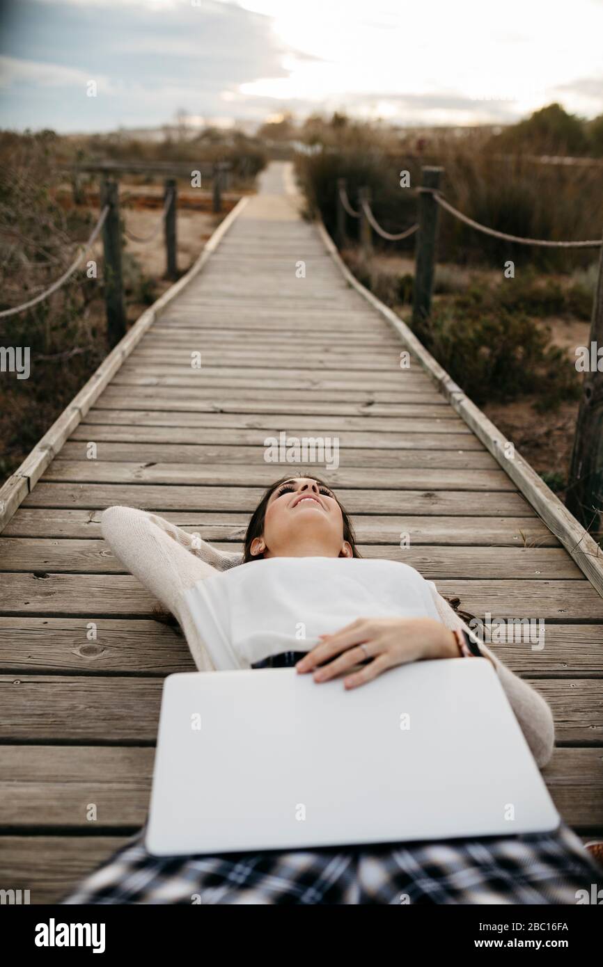 Femme posée sur une promenade dans la campagne avec ordinateur portable Banque D'Images