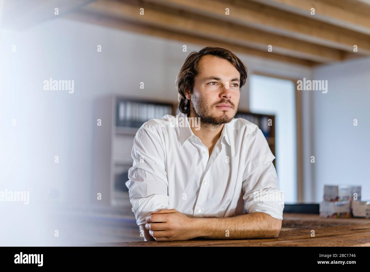 Portrait d'homme d'affaires dans un bureau en bois à plan ouvert Banque D'Images