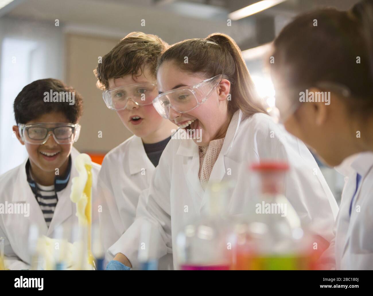 Les étudiants ont surpris de mener des expériences scientifiques en mousse explosant en laboratoire de classe Banque D'Images